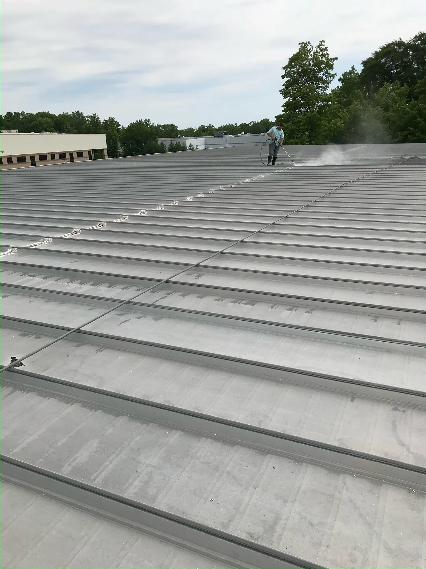 Top Notch Commercial Roofing applying protective coating to a commercial roof in Columbus, Ohio for long-term waterproofing and UV resistance.
